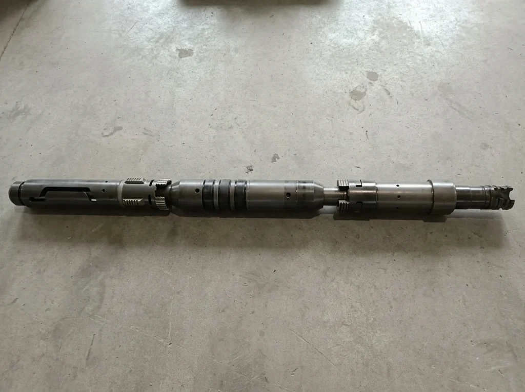 AS1-X double grip retrievable packer with upper and lower slip sets and packing elements lying on a shop floor