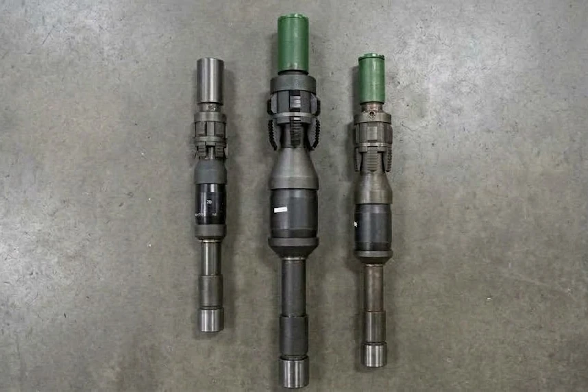 Three tension-set packers of different sizes laid flat on a shop floor