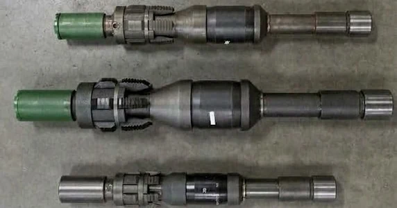 Three tension packers laid horizontally on a shop floor